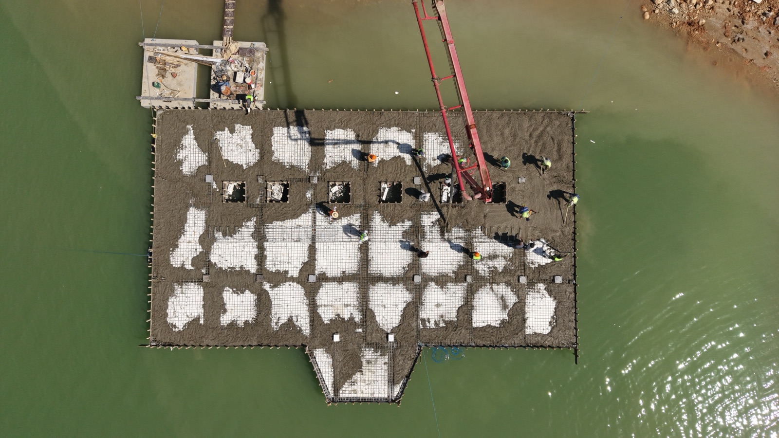 Workers pouring the concrete deck of the Khanke floating intake platform, seen from above